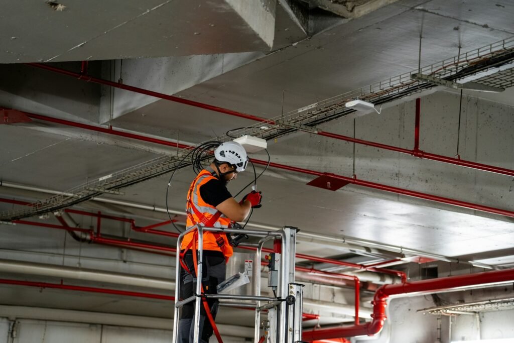 Technician installing ceiling services during an office fit-out