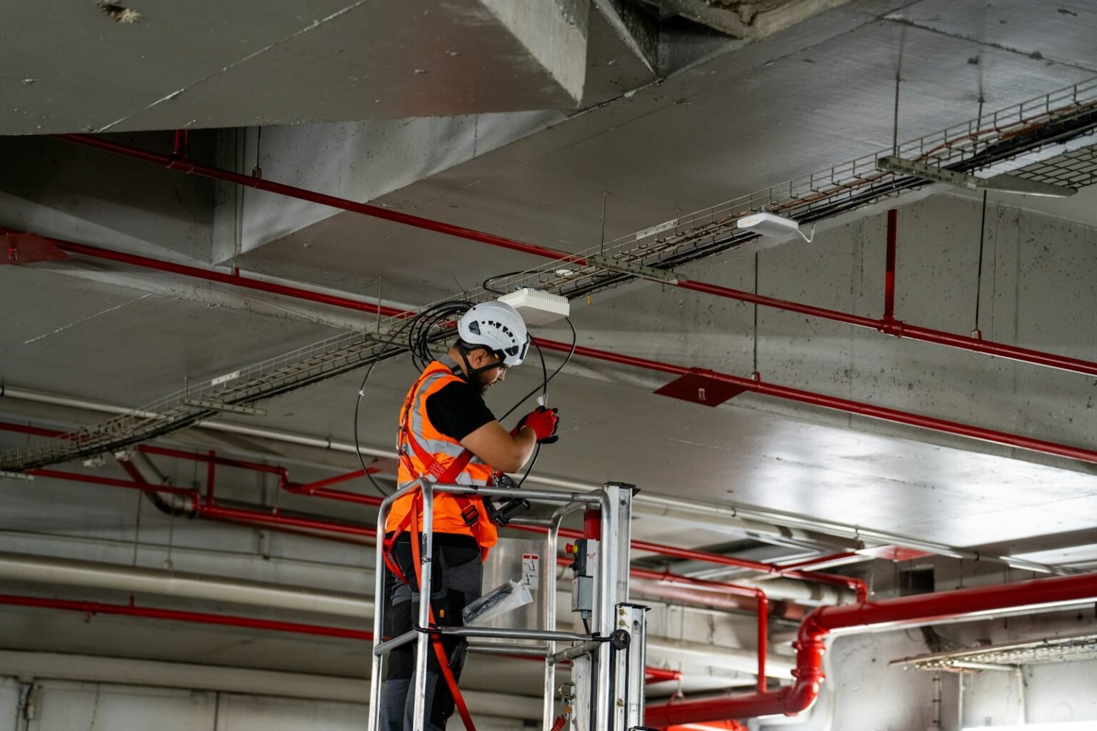 Technician installing ceiling services during an office fit-out