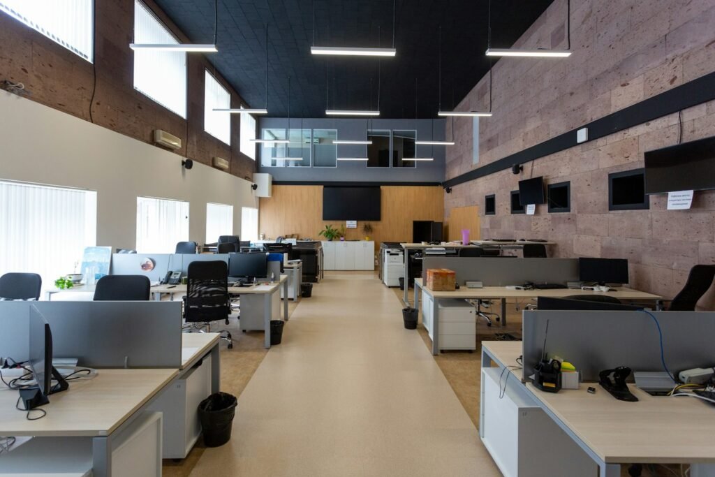 Rows of modular office workstations under linear lighting